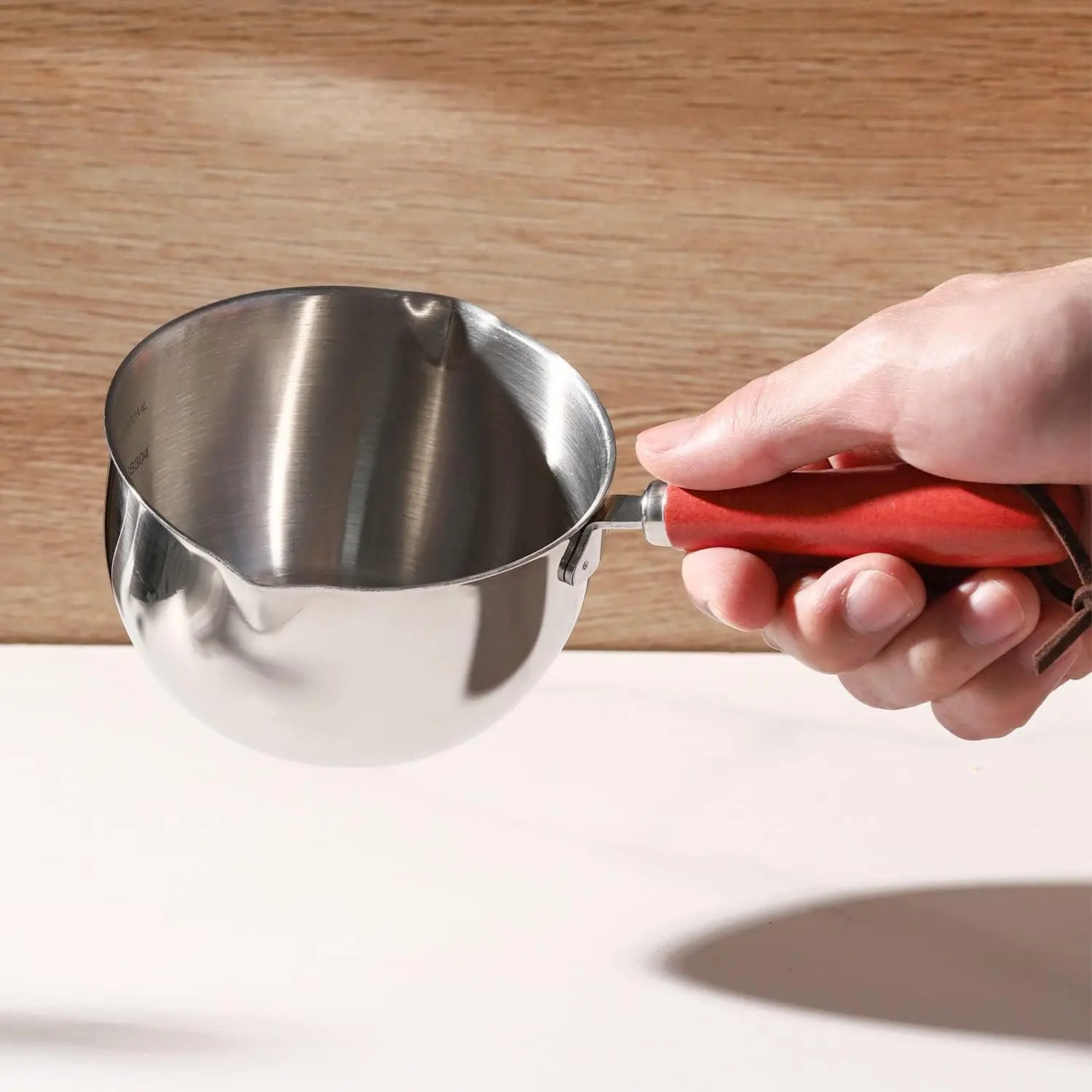CASSEROLE- À- HUILE- CHAUDE- POUR- ARROSAGE  : en-main