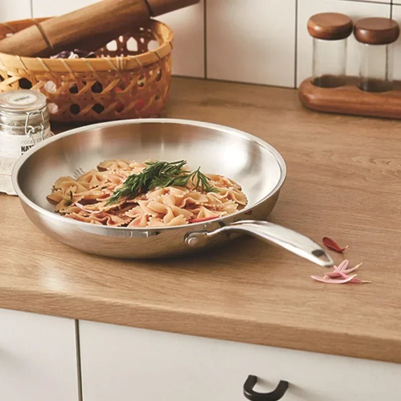 Poêle- en- acier- inoxydable- poli- rond-  induction : cuisson- uniforme- des - pâtes
