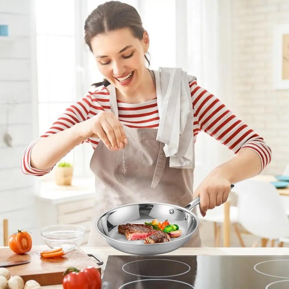 Poêle- en- acier- inoxydable- poli- rond-  induction :  mère- cuisinant- avec-  la- poêle