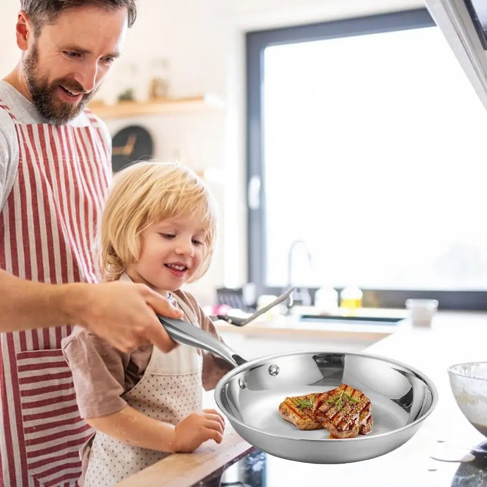 Poêle- en- acier- inoxydable- poli- rond-  induction :  père- cuisinant- avec- sa- fille