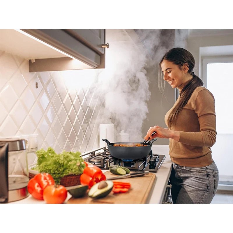 faitout- en- fonte - cocotte- ronde- avec couvercle :  dame- qui- cuisine- dans- le- faitout