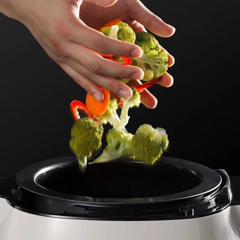 machine de cuisson avec main tenant des légumes